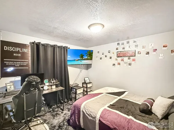 a bedroom with a bed and a refrigerator