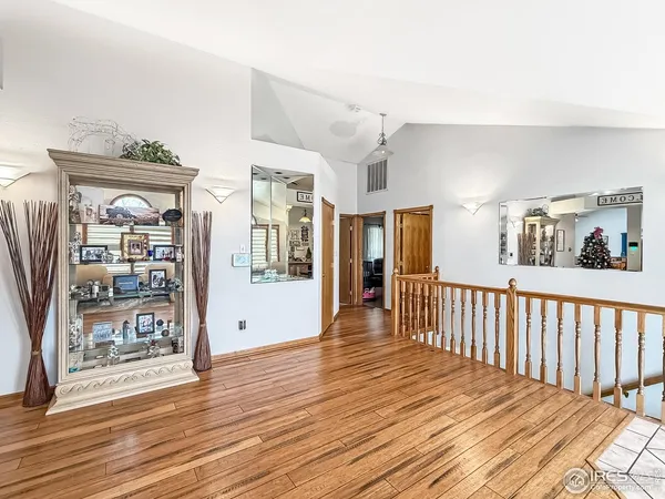 a view of a hallway with wooden floor and windows