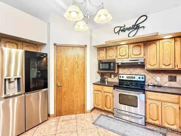 a kitchen with stainless steel appliances granite countertop a stove a refrigerator and a sink