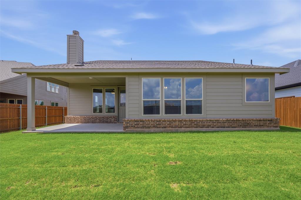 1217 Colca Drive Springtown, TX 76082 - Photo 23 of 25 Expansive green lawn bordering a single-story home featuring a covered patio, brick foundation, and multiple windows