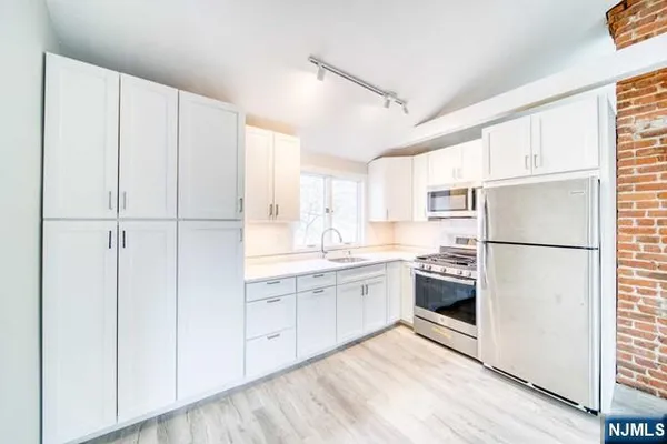 a kitchen with white cabinets and white appliances