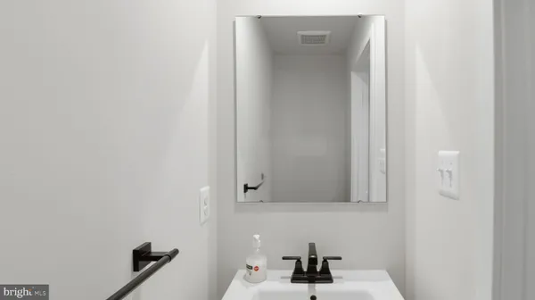 a white toilet sitting next to a white sink and vanity