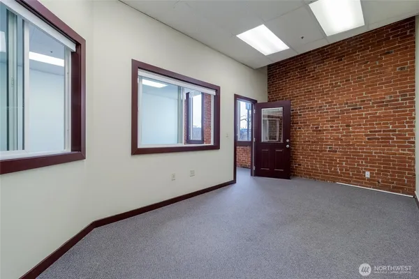 a view of an empty room with brick wall and closet