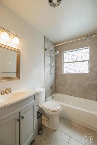 a bathroom with a toilet a sink a mirror and bathtub