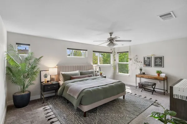 a bedroom with a bed table and a window