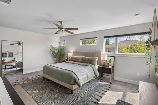 a bedroom with a bed a window and potted plant