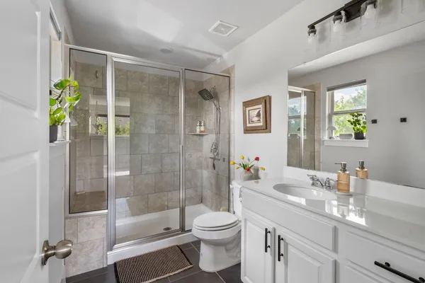 a bathroom with a sink a toilet and shower