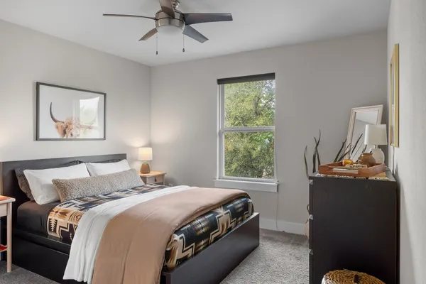 a bedroom with bed mirror and window