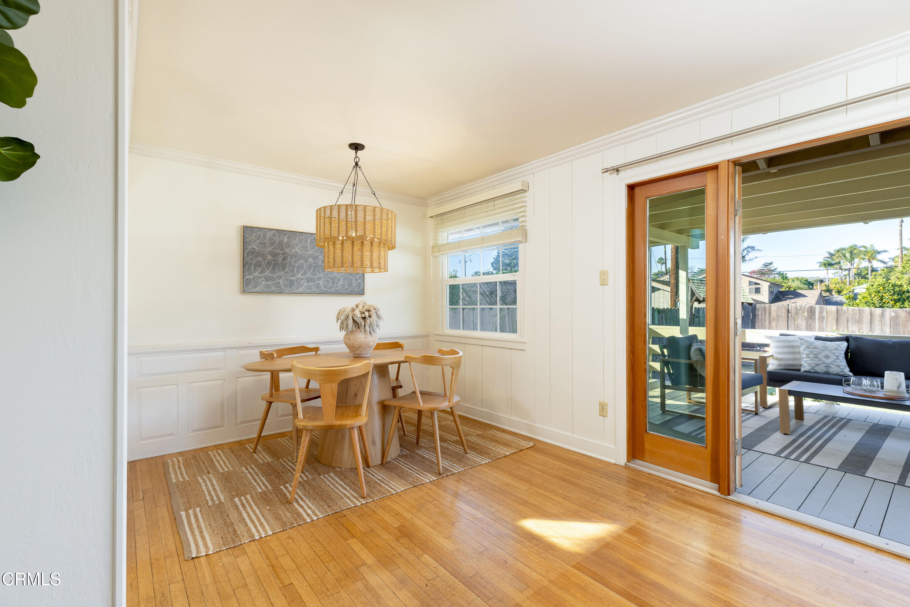 755 Calle Rey Mar Carpinteria, CA 93013 - Photo 4 of 18 a dining room with wooden floor a chandelier a wooden table and chairs