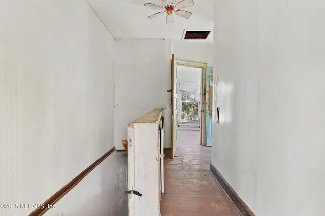 a view of a hallway with wooden floor and staircase