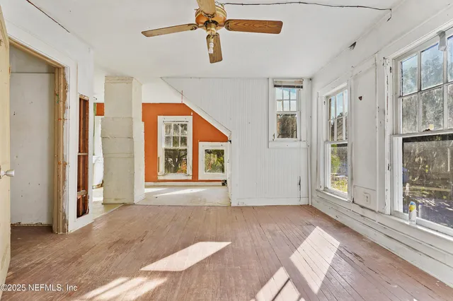 a view of a bedroom with wooden floor and windows