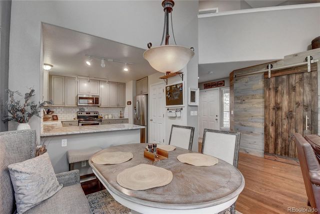 a kitchen with sink a refrigerator and chairs