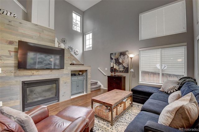 a living room with furniture a flat screen tv and a fireplace
