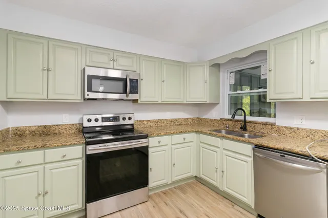 a kitchen with sink a microwave and cabinets