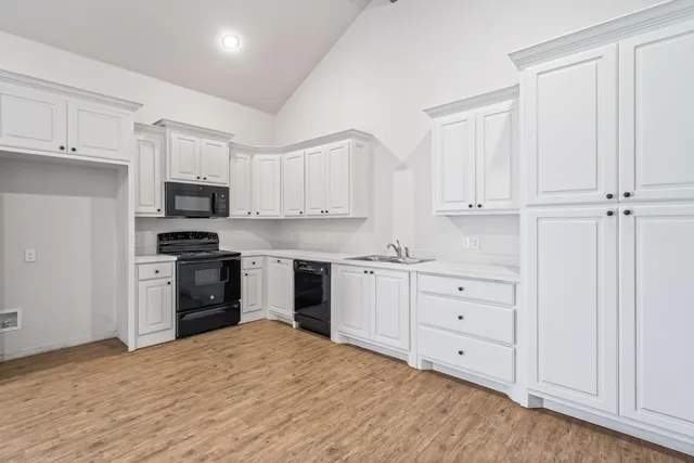 a kitchen with granite countertop white cabinets and stainless steel appliances