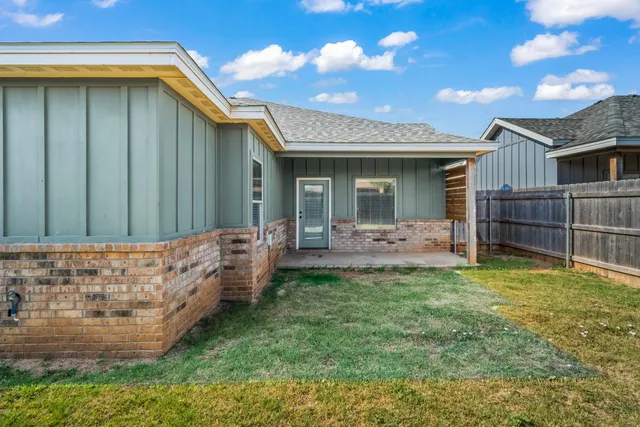 a view of a backyard with wooden fence