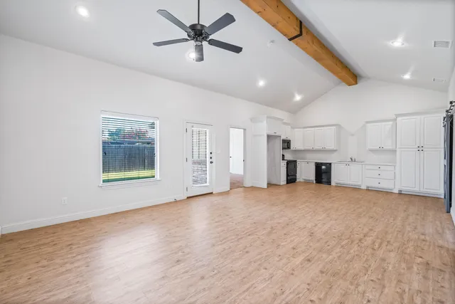a view of empty room with wooden floor and ceiling fan