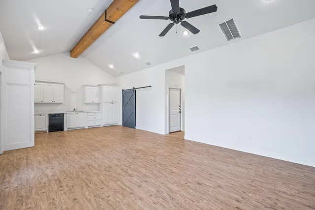 a view of empty room with wooden floor and window