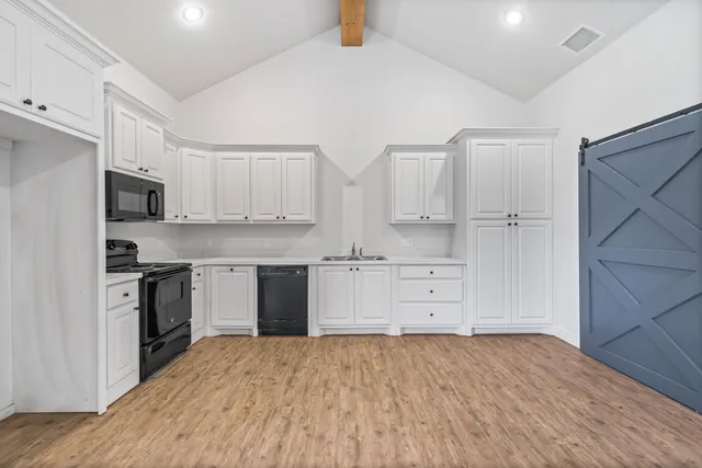 a kitchen with white cabinets and stainless steel appliances