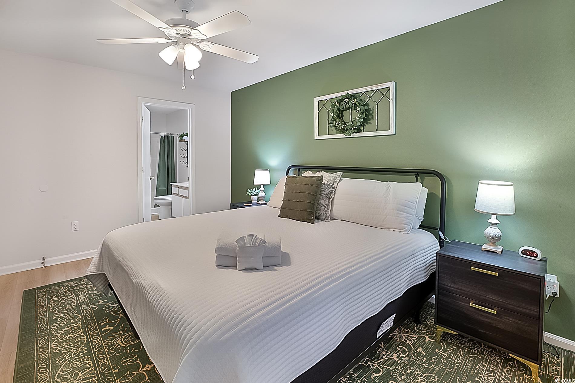 1204 River Oaks Drive, Unit 25D Myrtle Beach, SC 29579 - Photo 16 of 31 Bedroom with a ceiling fan, connected bathroom, and wood finished floors