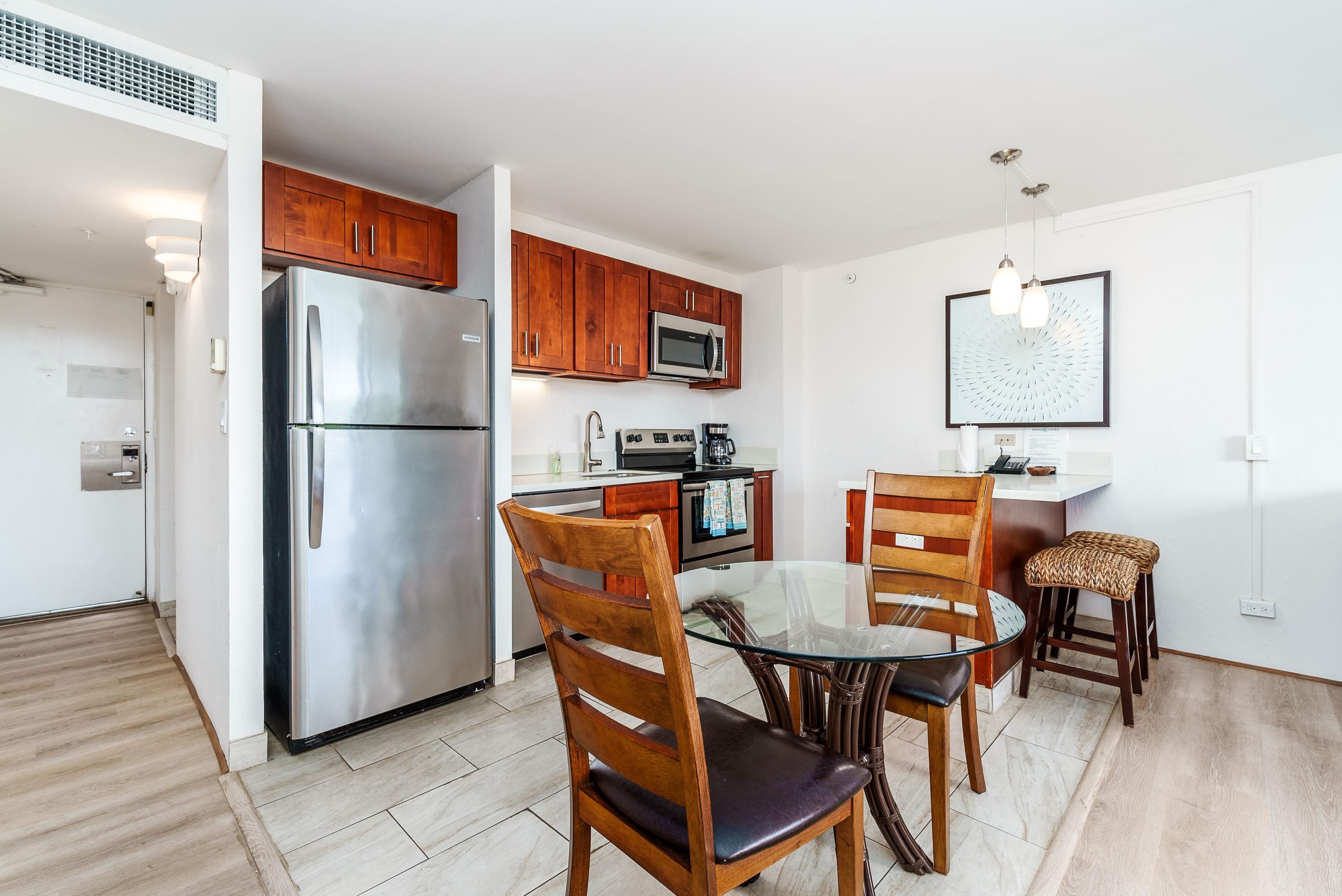3445 Lower Honoapiilani Road, Unit 434 Lahaina, HI 96761 - Photo 11 of 46 a kitchen with stainless steel appliances a dining table chairs and a refrigerator