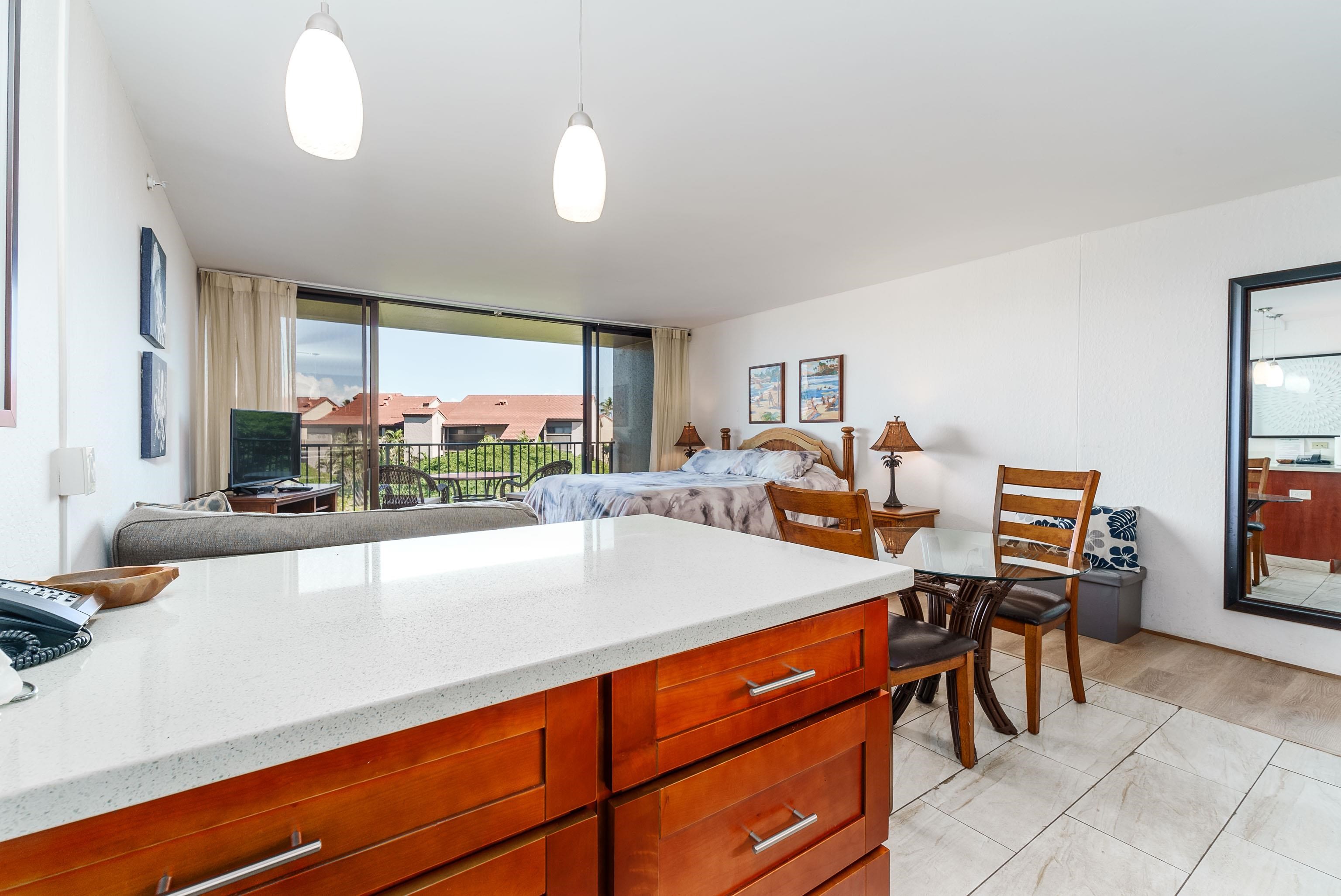 3445 Lower Honoapiilani Road, Unit 434 Lahaina, HI 96761 - Photo 14 of 46 a large living room with stainless steel appliances kitchen island granite countertop furniture and a large window