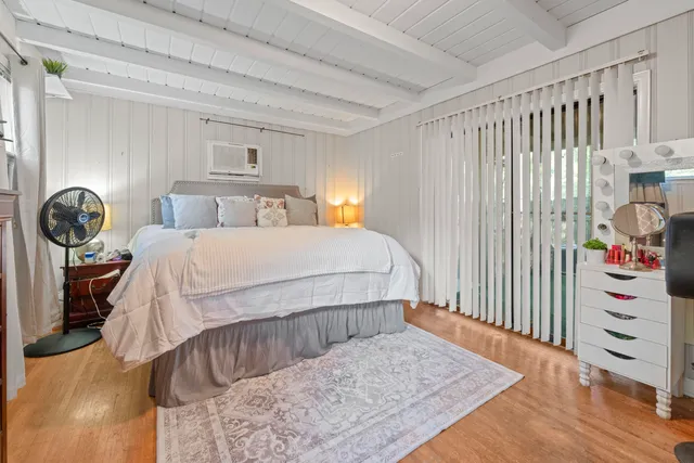 a bedroom with a bed a chandelier and dresser