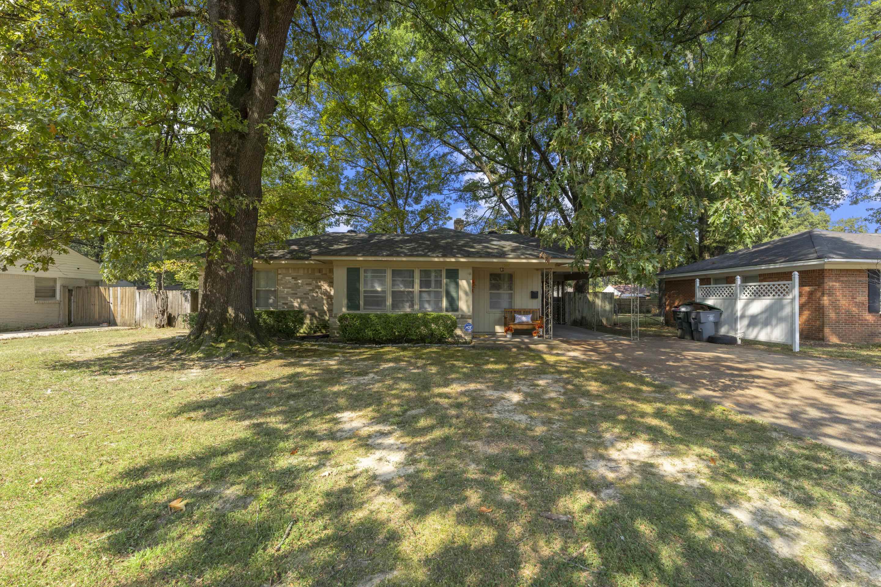 1597 Marcia Road Memphis, TN 38117 - Photo 2 of 19 a front view of a house with a garden and trees