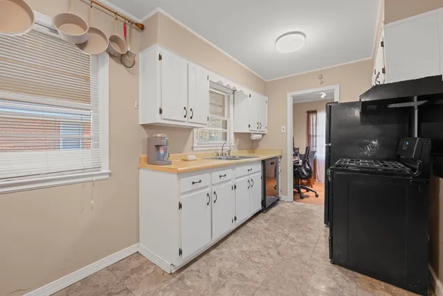 a kitchen with white cabinets and refrigerator
