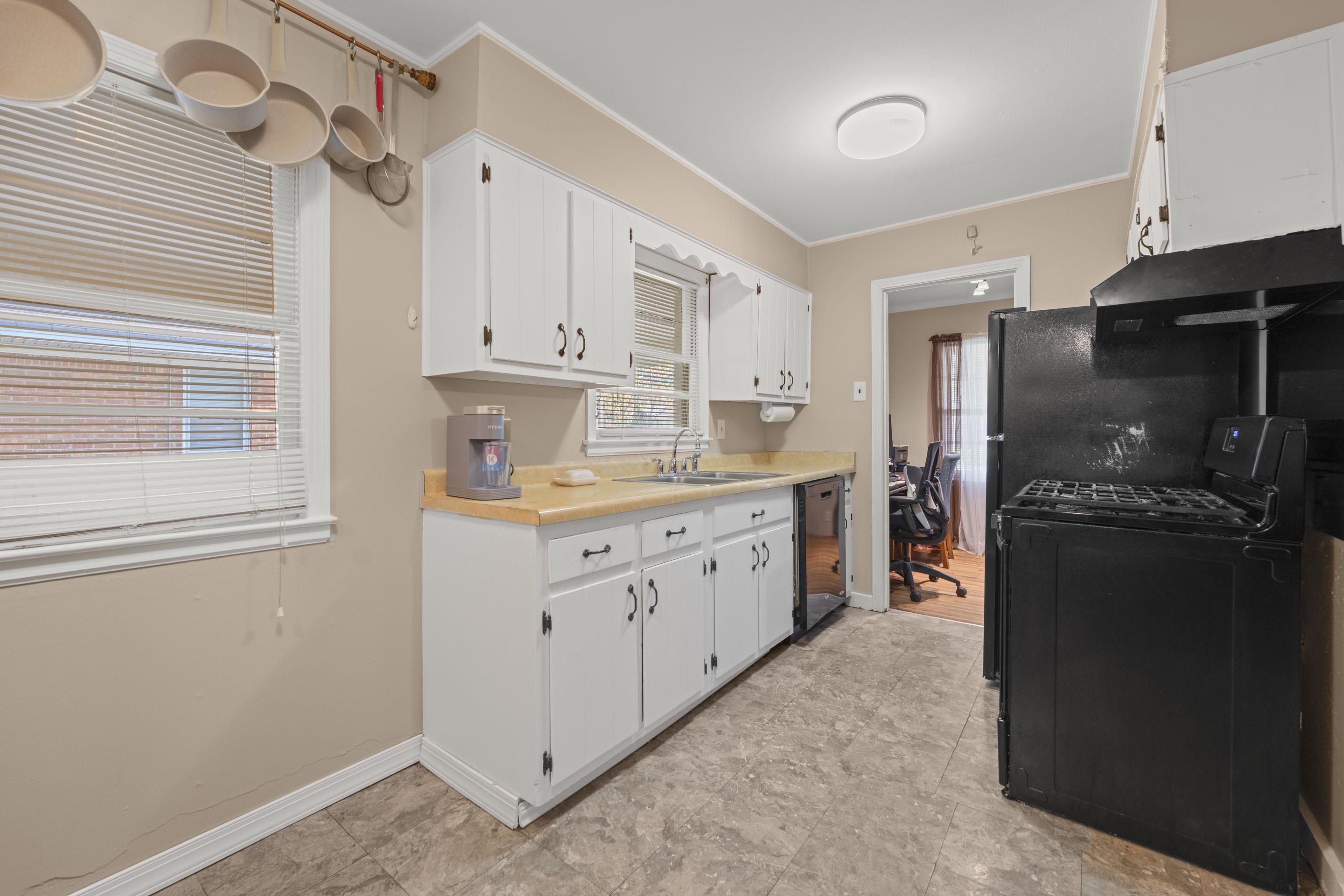 1597 Marcia Road Memphis, TN 38117 - Photo 9 of 19 a kitchen with white cabinets and refrigerator