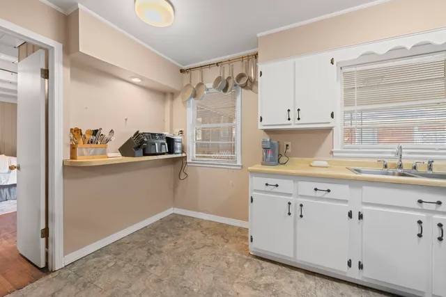 a kitchen with white cabinets and a sink