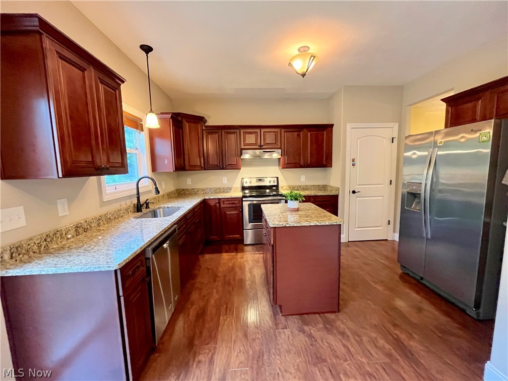 1134 Mayfield Ridge Road Cleveland, OH 44124 - Photo 12 of 41 Kitchen featuring pendant lighting, appliances with stainless steel finishes, a kitchen island, sink, and dark hardwood / wood-style flooring