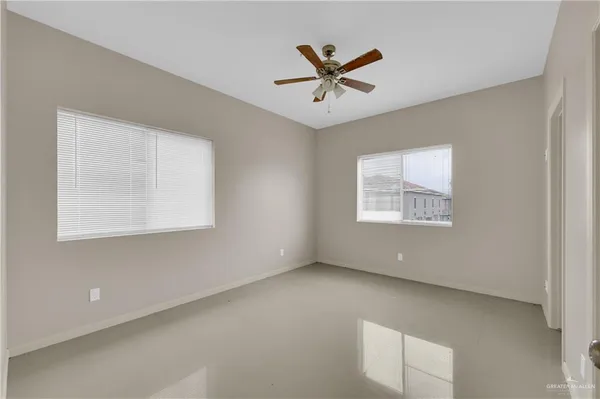 a view of a big room with wooden floor and windows