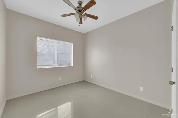 an empty room with a window and a fan