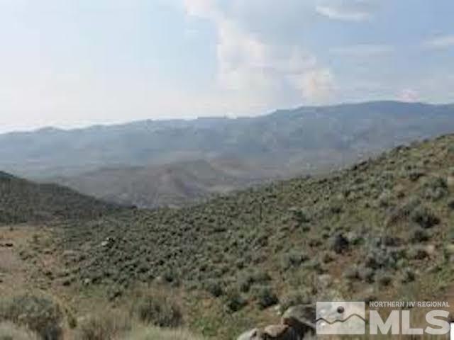 a view of a dry yard with mountains in the background