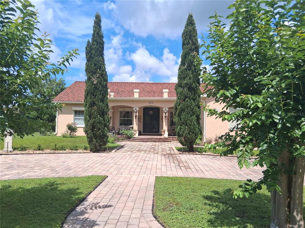 915 Old Welcome Road Lithia, FL 33547 - Photo 3 of 23 a front view of a house with a yard and potted plants