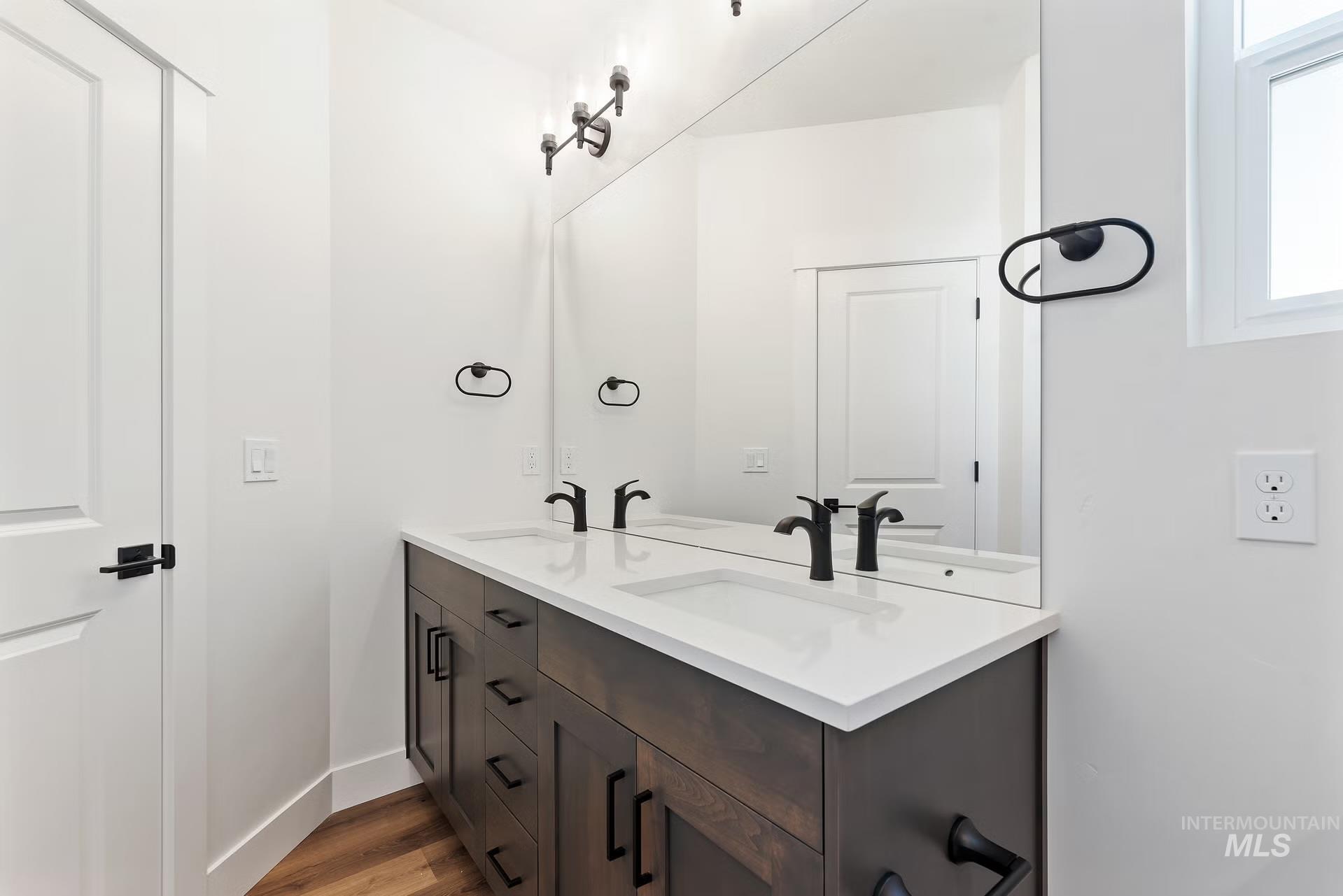 716 South Calhoun Lane Star, ID 83669 - Photo 16 of 23 Bathroom featuring double vanity, wood finished floors, and healthy amount of natural light