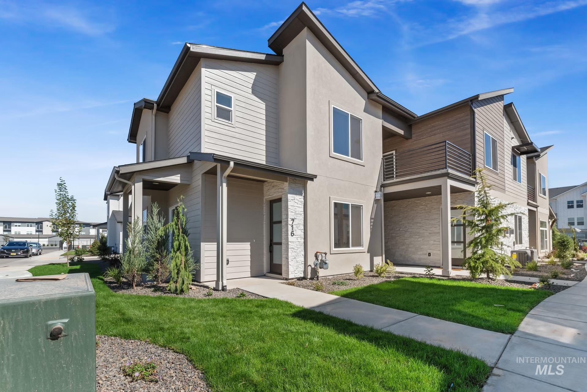 716 South Calhoun Lane Star, ID 83669 - Photo 2 of 23 View of front facade with stone siding, a front yard, stucco siding, and a balcony