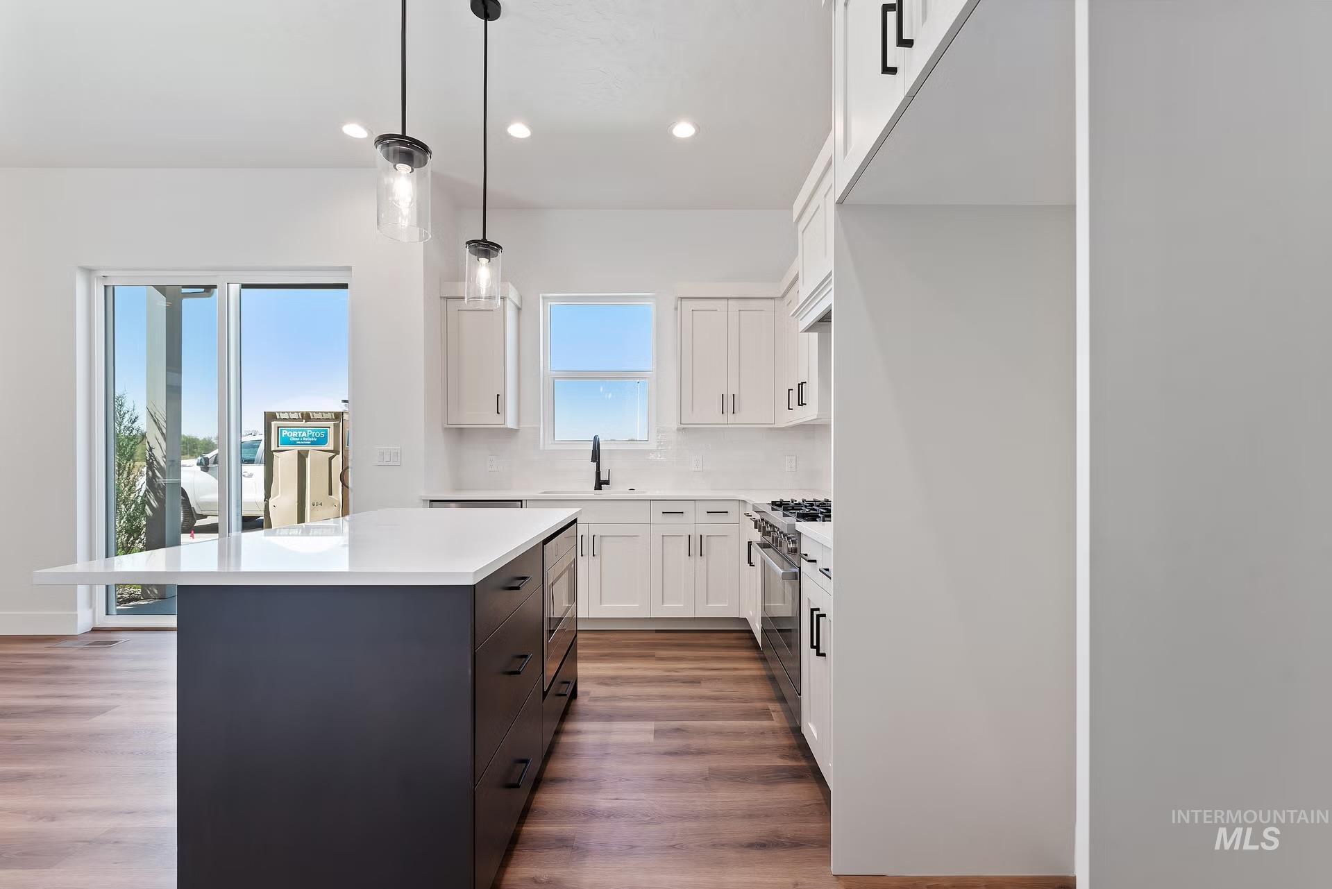 716 South Calhoun Lane Star, ID 83669 - Photo 5 of 23 Kitchen with white cabinets, backsplash, pendant lighting, a kitchen island, and recessed lighting