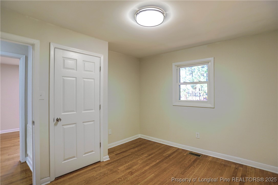 222 Odell Road Spring Lake, NC 28390 - Photo 12 of 17 an empty room with wooden floor and windows