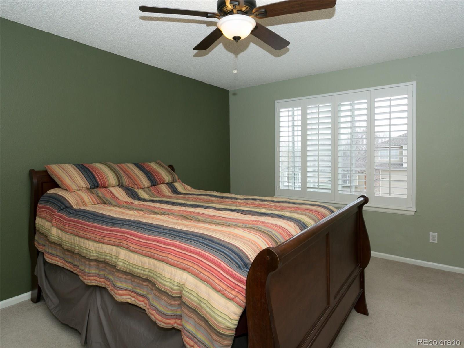 9565 South Castle Ridge Circle Highlands Ranch, CO 80129 - Photo 12 of 25 a bedroom with a bed and a chandelier