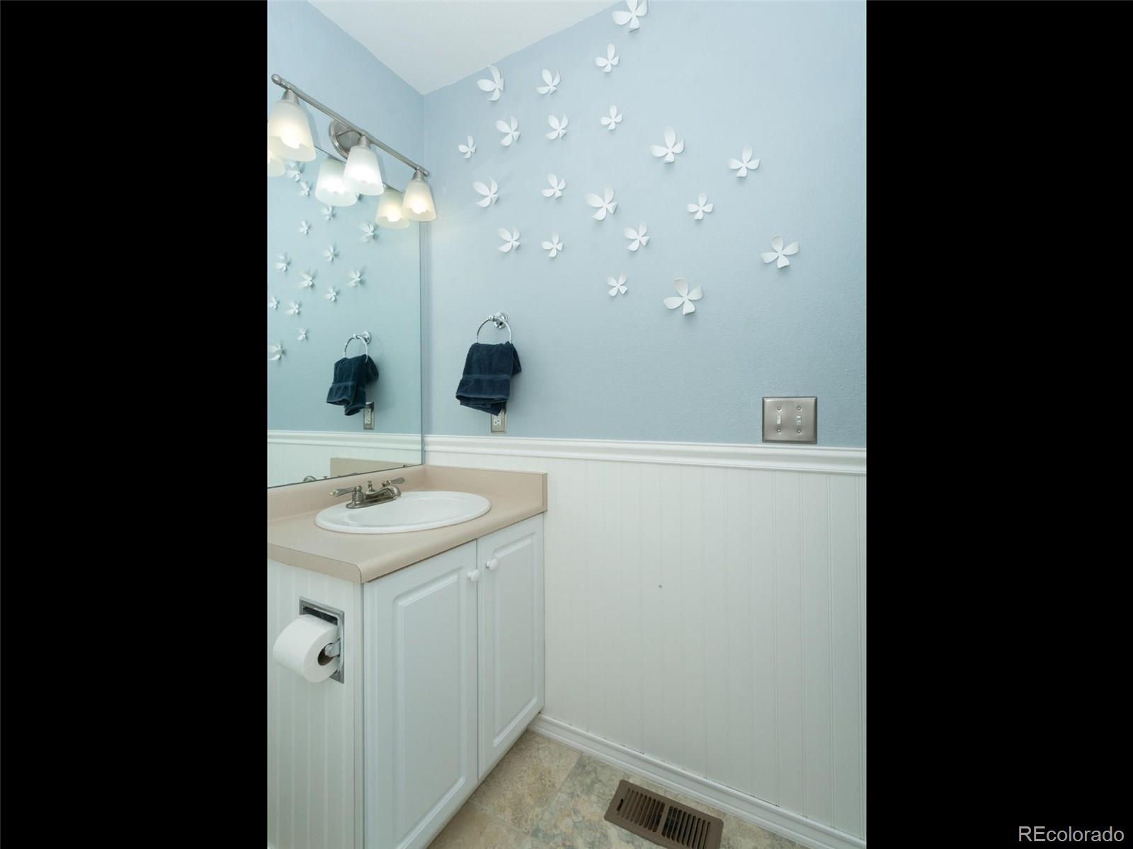 9565 South Castle Ridge Circle Highlands Ranch, CO 80129 - Photo 17 of 25 a bathroom with a sink a toilet and mirror
