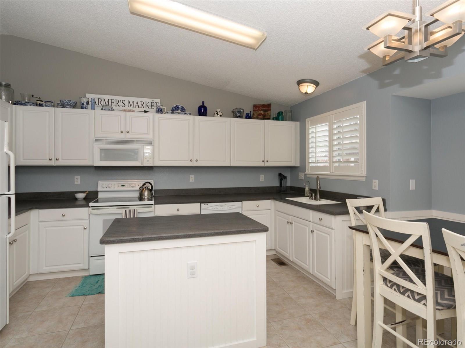 9565 South Castle Ridge Circle Highlands Ranch, CO 80129 - Photo 6 of 25 a kitchen with a sink a stove and cabinets
