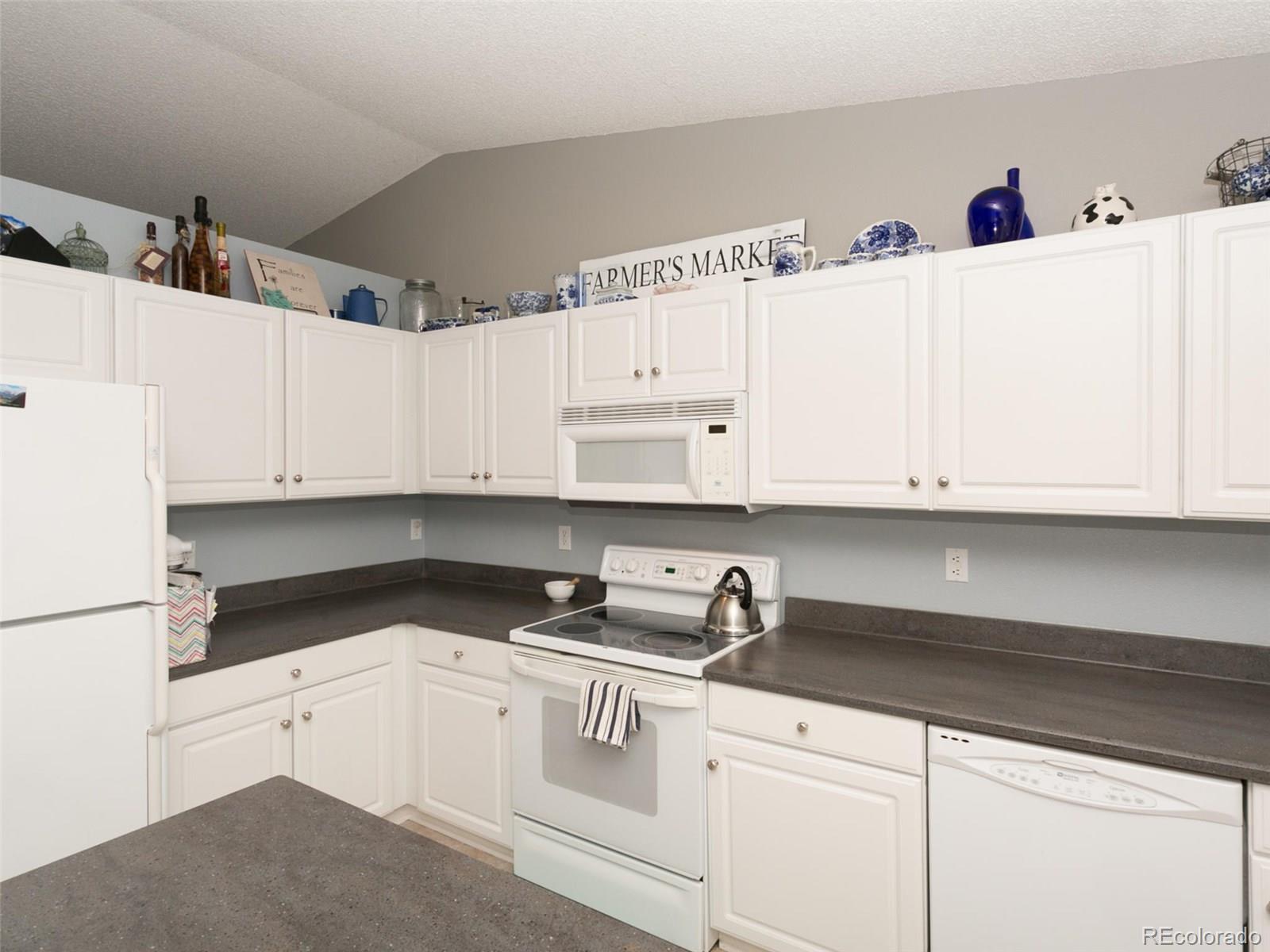 9565 South Castle Ridge Circle Highlands Ranch, CO 80129 - Photo 7 of 25 a kitchen with white cabinets and sink