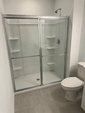 a bathroom with a toilet and a shower