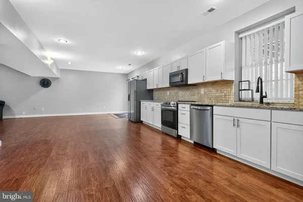 a kitchen with granite countertop white cabinets and stainless steel appliances