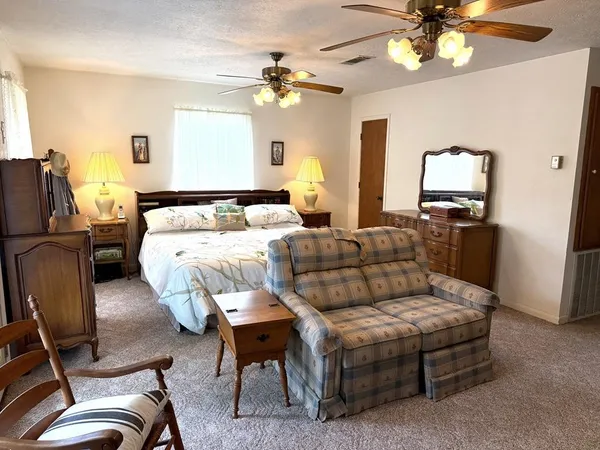 a living room with furniture a chandelier and a flat screen tv
