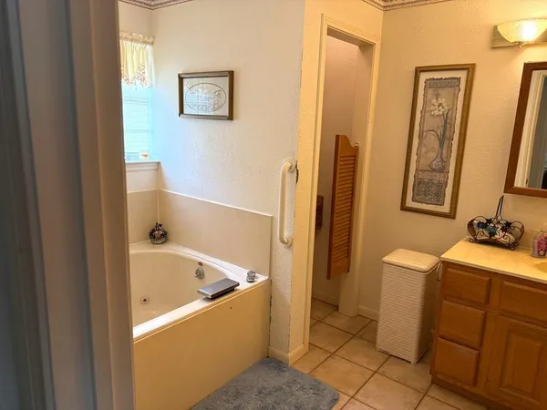 a bathroom with a tub sink and mirror