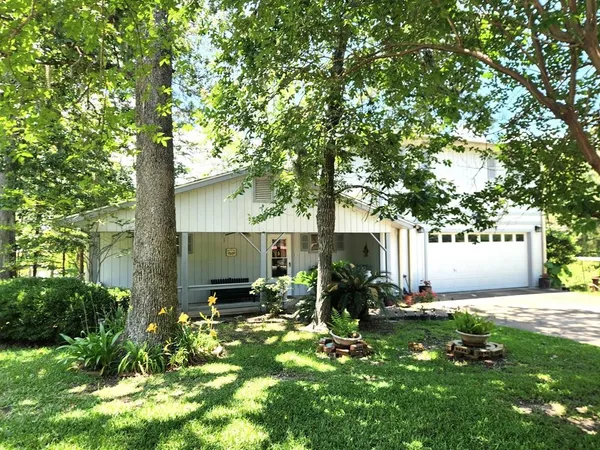 a view of a house with backyard and a tree