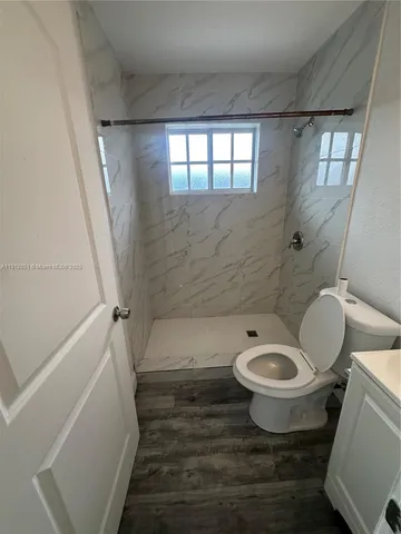 a white toilet sitting next to a bath tub